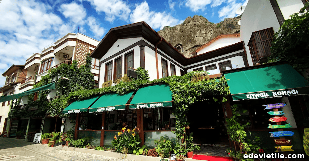 Ziyagil Konağı guesthouse in Amasya. Charming, ivy-covered white guesthouse with green awnings and traditional architecture, nestled at the foot of the rocky cliffs in Amasya.