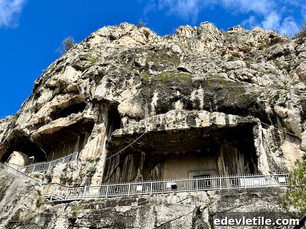 Ancient royal tombs of the Pontic Kings carved high into the rocky cliffs of Amasya, backed by a deep blue sky.