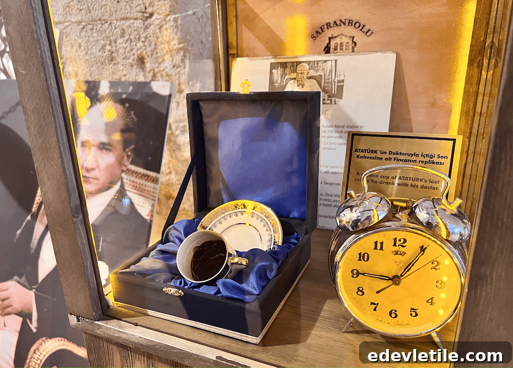 Museum display showing a replica of the last coffee cup used by Atatürk, inside a velvet-lined box next to an old-fashioned yellow clock and informational plaque.