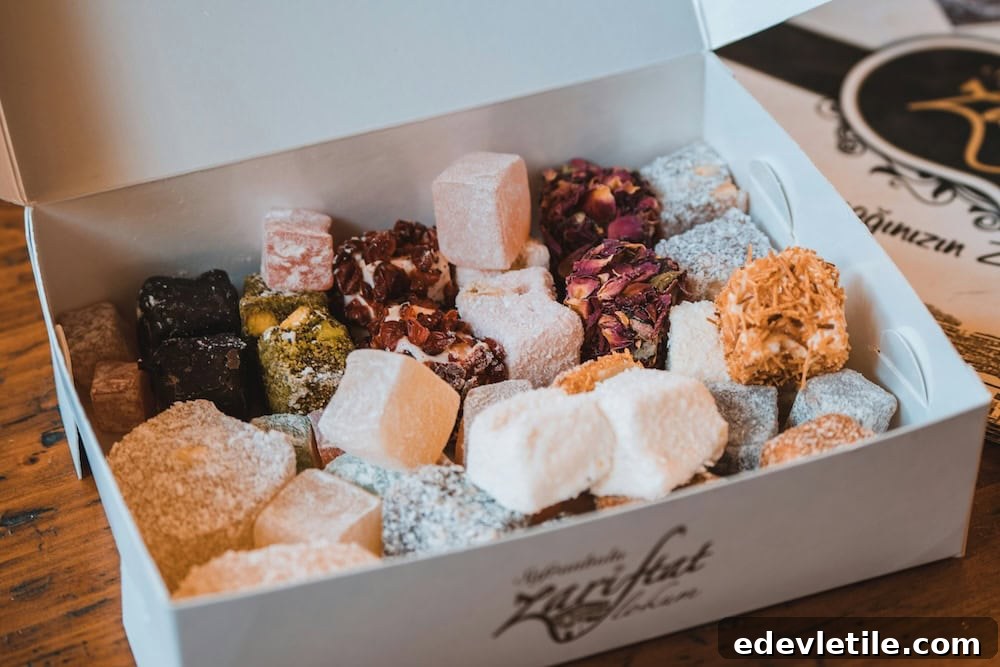 Open box displaying colorful varieties of Turkish delight including rose petal, pistachio, and coconut-covered pieces, arranged neatly for gifting.