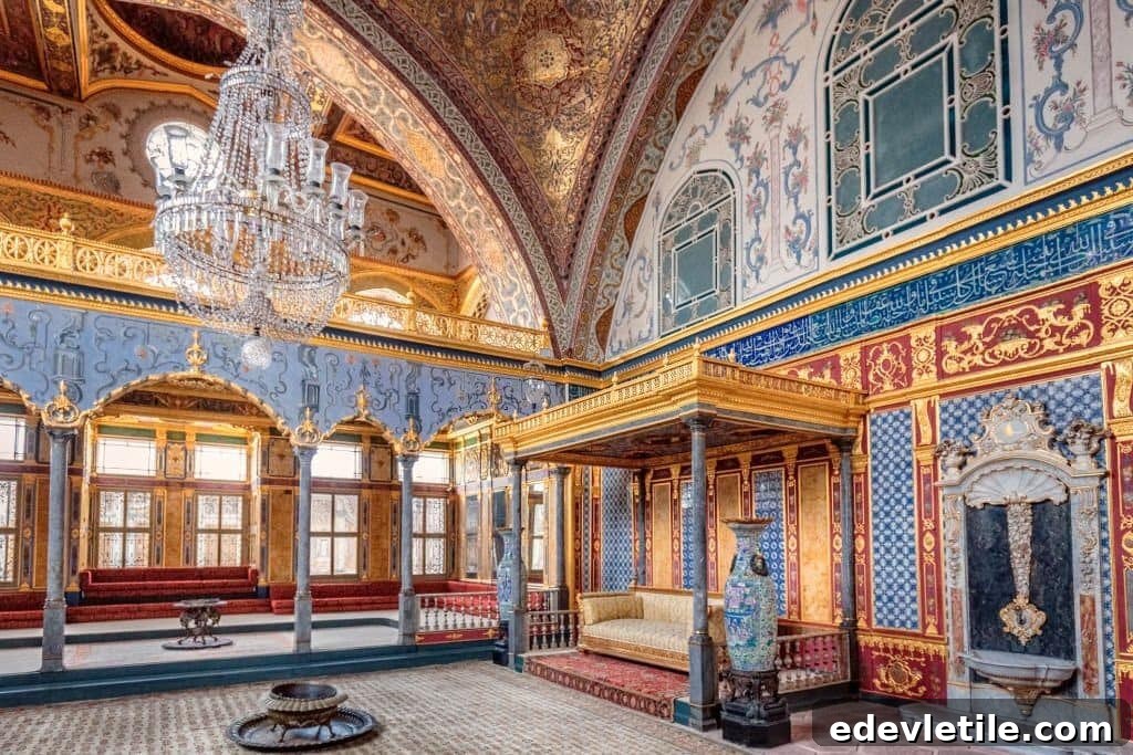 The lavishly decorated interior of a room in Topkapı Palace features gold accents, detailed Islamic art, and a grand chandelier, representing Ottoman imperial history.