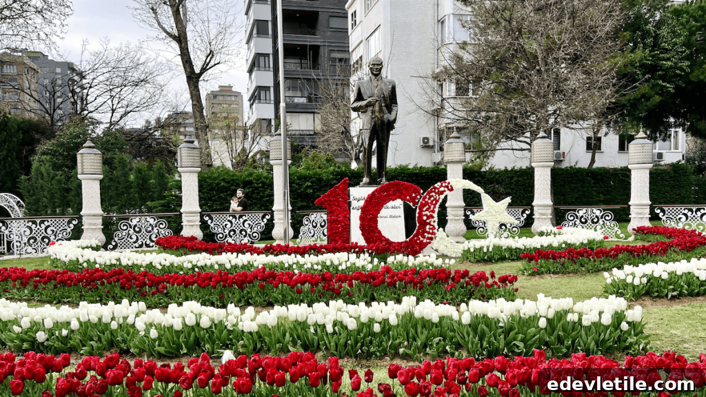 A large floral installation celebrating the Turkish Republic’s 100th anniversary with red and white tulips forming the number “100” and crescent-star, set in front of a statue of Atatürk.