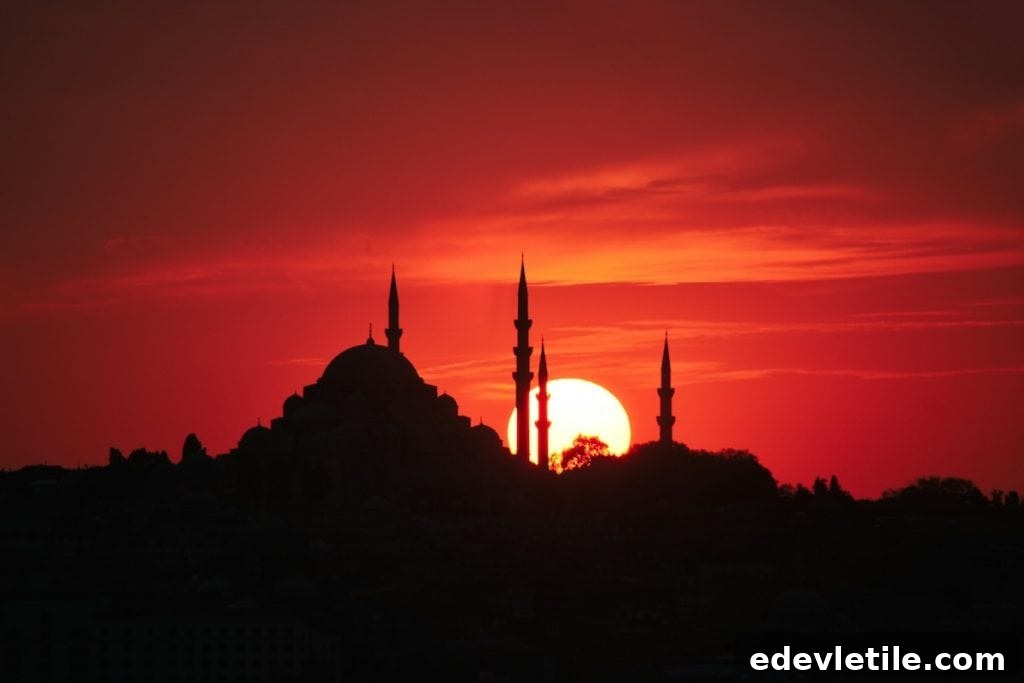 Silhouette of a mosque at sunset in Istanbul with the sun glowing deep orange behind the minarets during Ramadan.