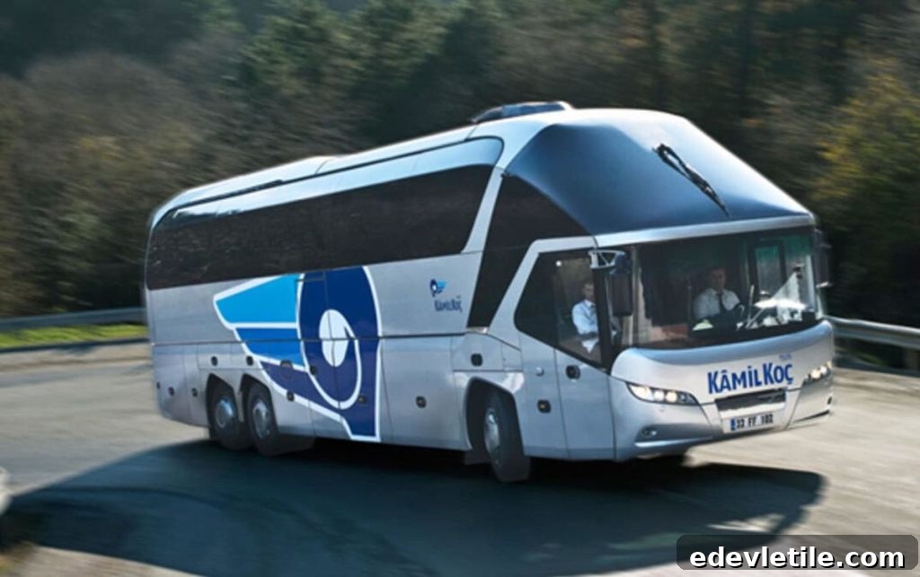 Kamil Koç intercity bus driving on a curving highway, with two drivers visible through the windshield.