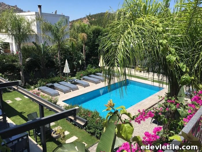 Lush, garden-style hotel in Bodrum with a sparkling pool, surrounded by palm trees, tropical greenery, and lounge chairs in a peaceful courtyard setting.