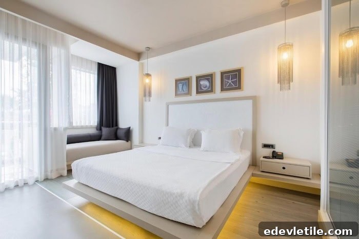 Modern minimalist hotel room in Bodrum with a floating bed frame, backlit base, soft white palette, and large windows letting in natural light.