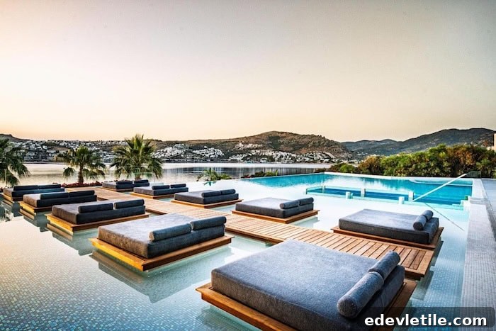 Infinity pool at a luxury hotel in Bodrum with floating sunbeds overlooking the bay and whitewashed buildings scattered along the hills.