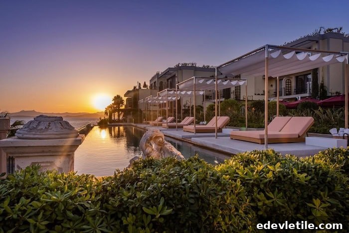 Luxury beachfront resort in Bodrum at sunset, with elegant cabanas lined up beside an infinity pool overlooking the sea.