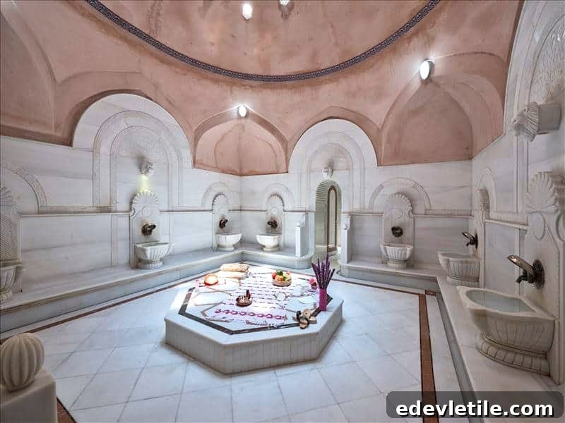 Warm-toned marble room at Acemoğlu Hamam with carved fountain basins and an octagonal central platform adorned with fruit and spa accessories.