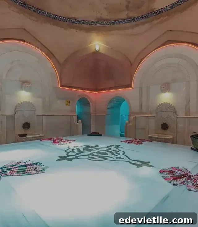 Illuminated dome and traditional Turkish towels arranged on the heated slab in Acemoğlu Hamam, with soft orange lighting along the arches.