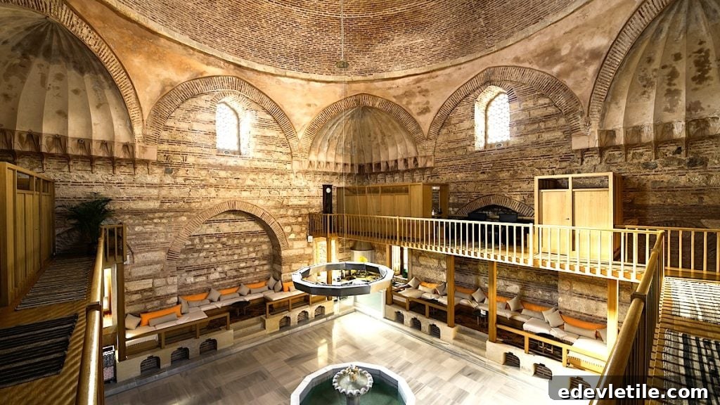Historic dome-roofed Kılıç Ali Paşa Hamam with exposed stone walls, arched windows, and seating areas around a central fountain and octagonal layout.