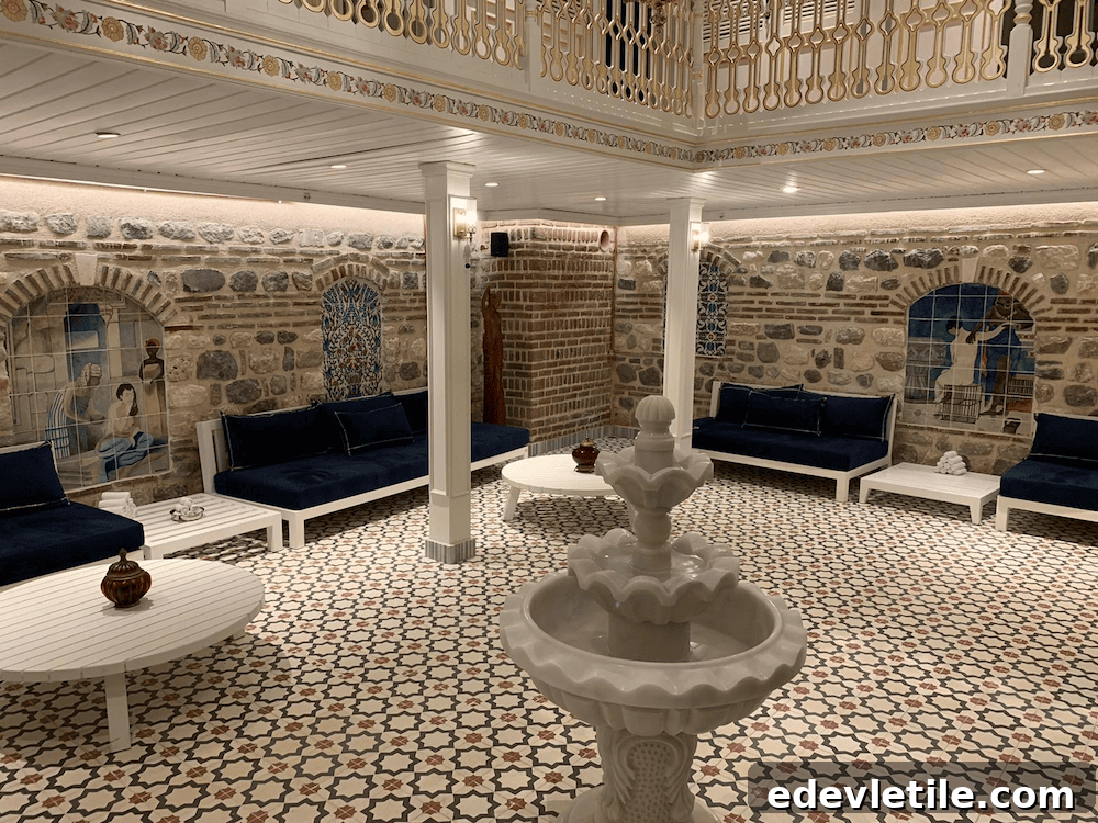 Elegant common area at Çatma Mescit Hamam with navy velvet sofas, patterned tile floors, Ottoman-style murals, and a central marble fountain.