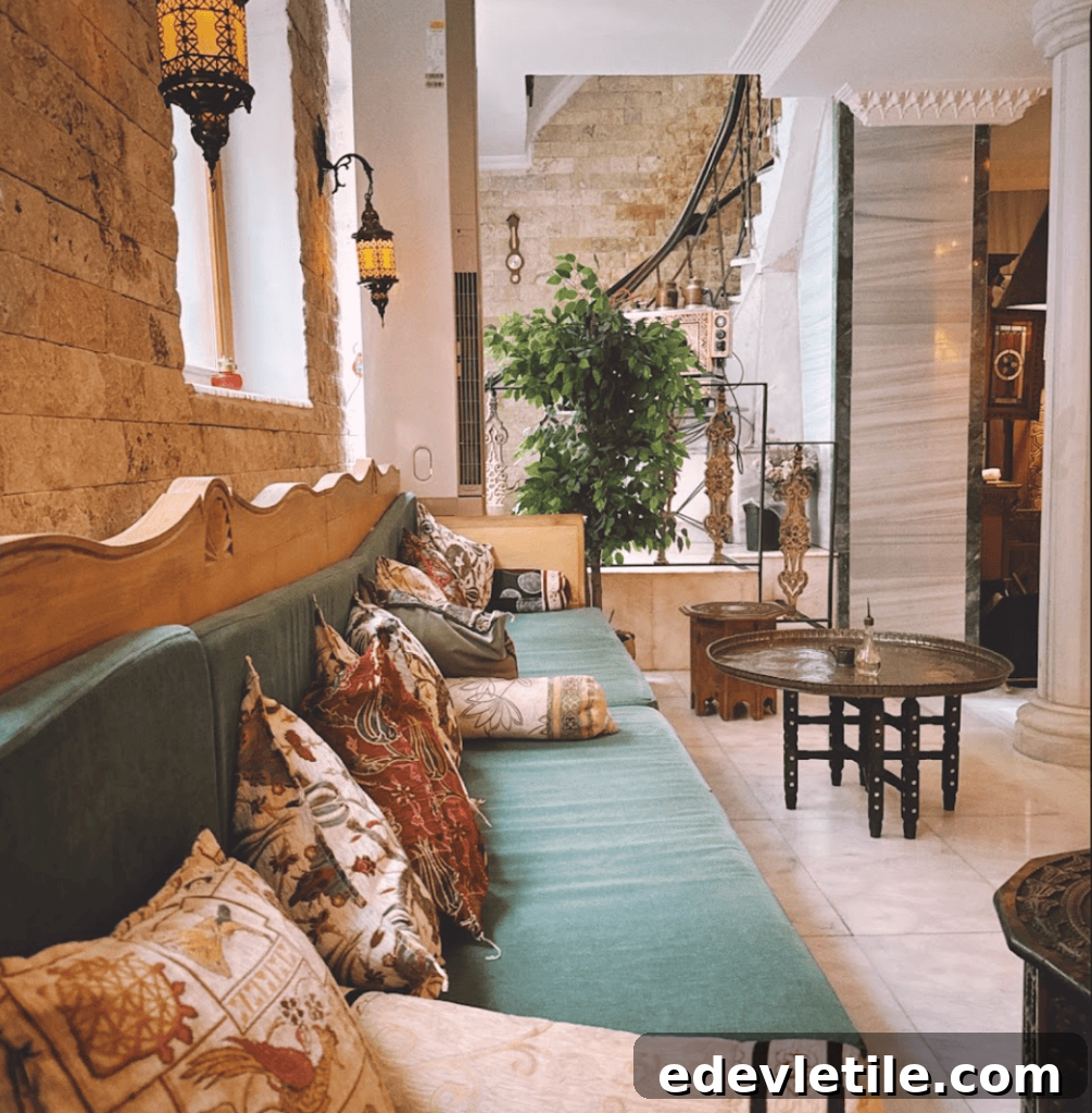 Cozy seating area at Aga Hammam with green cushioned bench, embroidered pillows, and traditional hanging lanterns in an elegant interior.