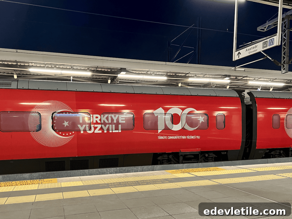 Red high-speed train at a station platform with “Türkiye Yüzyılı” (Century of Turkey) and “100” logos, marking the Republic’s centennial.
