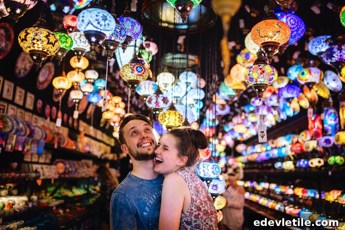 Smiling couple surrounded by colorful mosaic Turkish lamps in a vibrant Grand Bazaar-style shop.