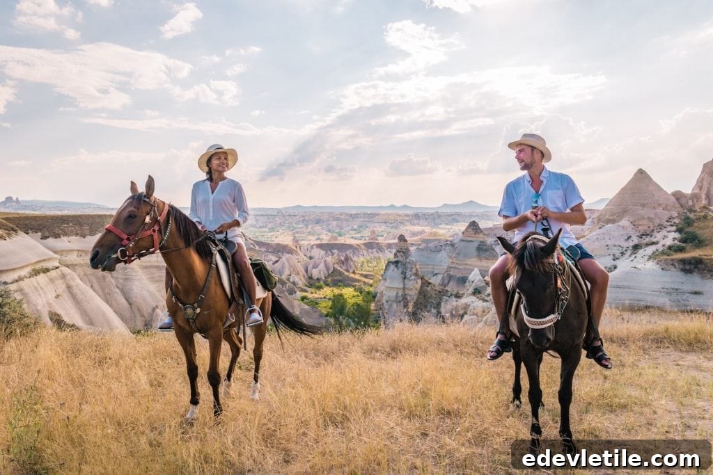 Couple riding horses through the scenic rocky valleys of Cappadocia at golden hour, surrounded by unique rock formations.