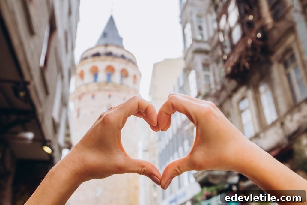 Hands forming a heart shape in front of the historic Galata Tower in Istanbul’s old town.
