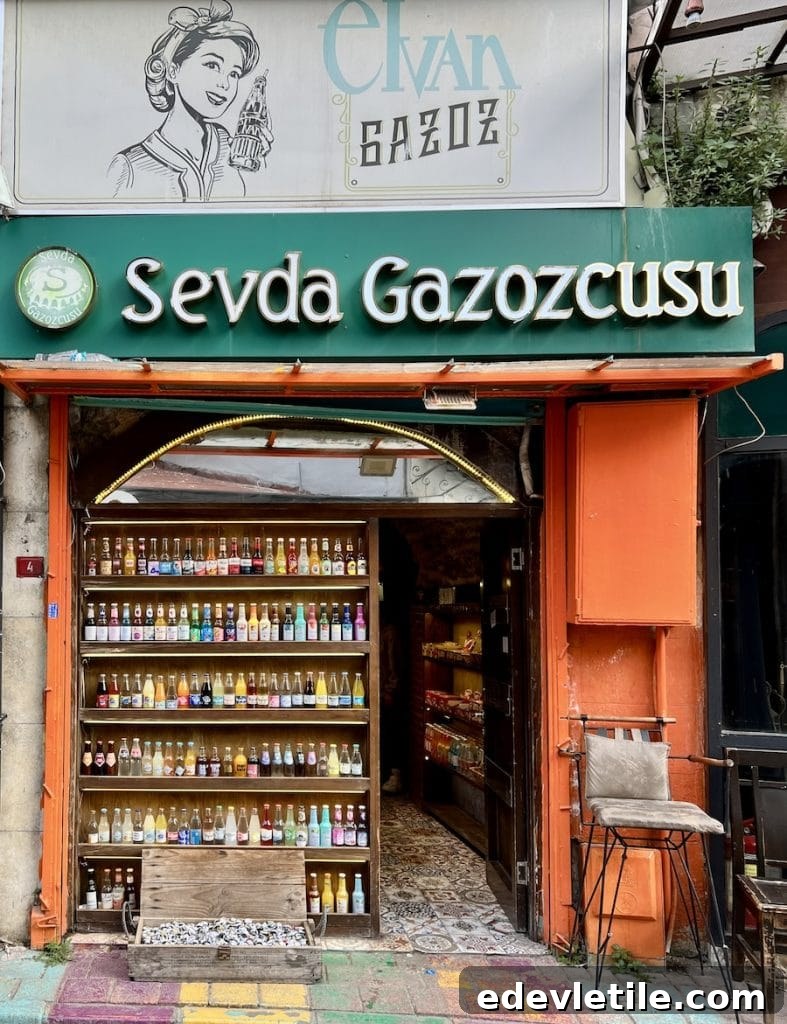 Colorful soda bottles neatly arranged on shelves at Sevda Gazozcusu in Balat, with a green storefront and vintage-style signage above the entrance.