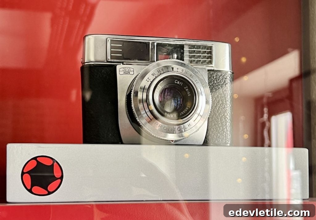 Close-up of a vintage Zeiss Ikon film camera on display in a red-walled gallery at Red Art House in Balat.