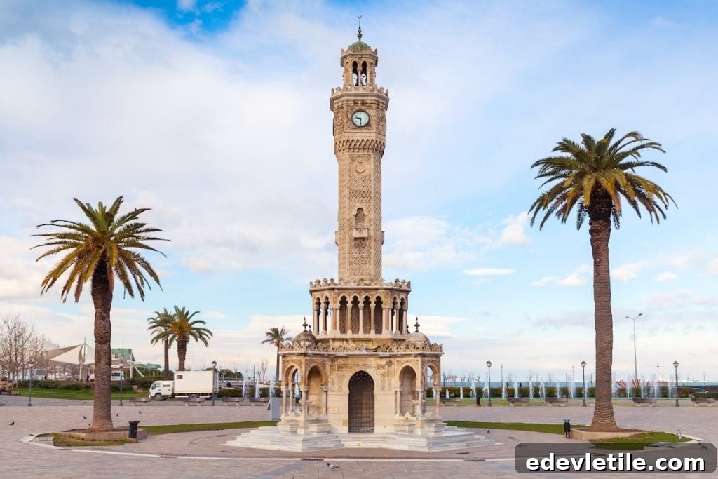 The historic Izmir Clock Tower in Konak Square surrounded by palm trees and clear skies during a spring afternoon.