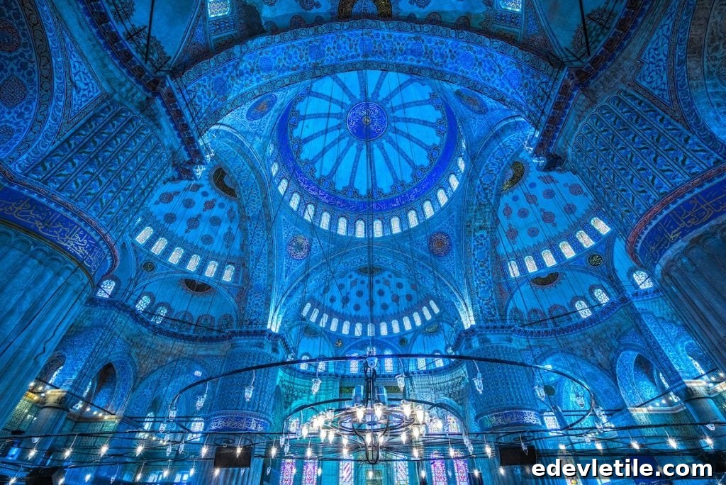 Stunning interior of the Blue Mosque with deep blue Iznik tiles, massive domes, arched windows, and ornate Islamic calligraphy.