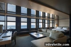 Luxury suite with harbor views in Izmir.
Spacious and modern hotel suite with large windows looking out over the sea, furnished with neutral-toned seating, a desk, and a bed.