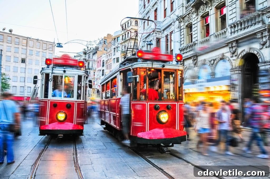 Iconic red vintage trams moving through the lively crowds on Istiklal Street in Istanbul’s Galata district.