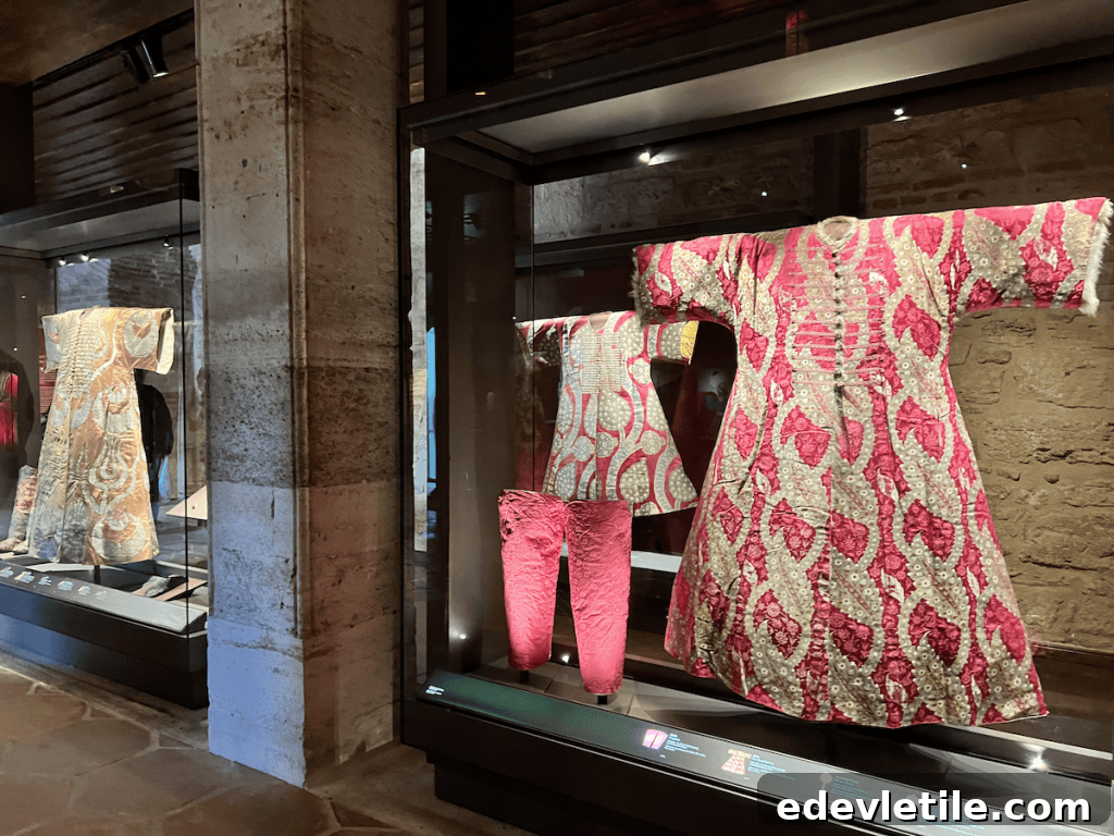 Exhibit showcasing richly embroidered Ottoman royal clothing and ceremonial garments in glass cases.