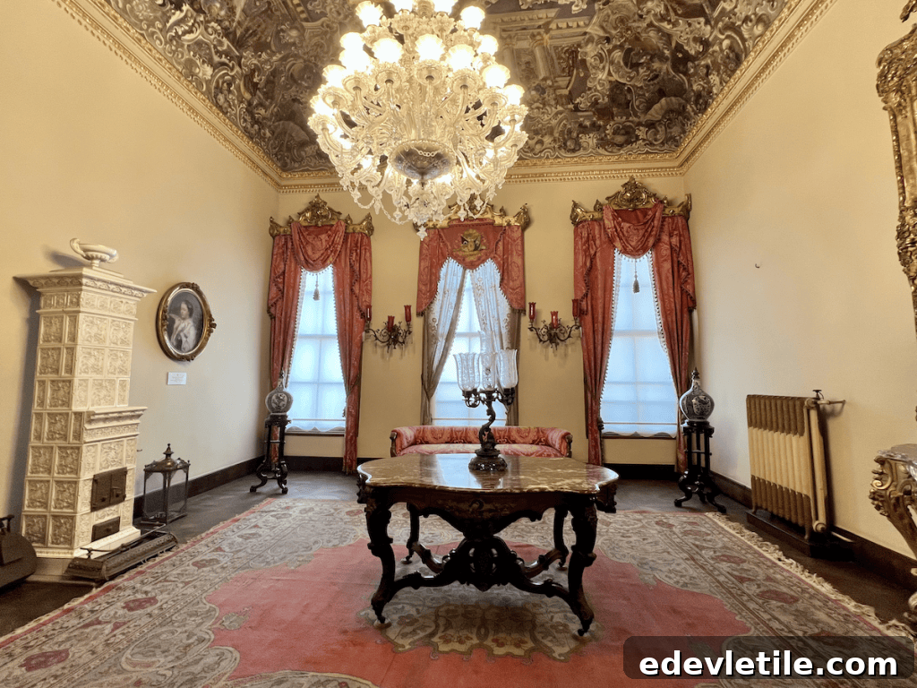 Intimate room in the Dolmabahçe Palace Harem with a detailed ceiling mural, antique furniture, and red velvet drapes.