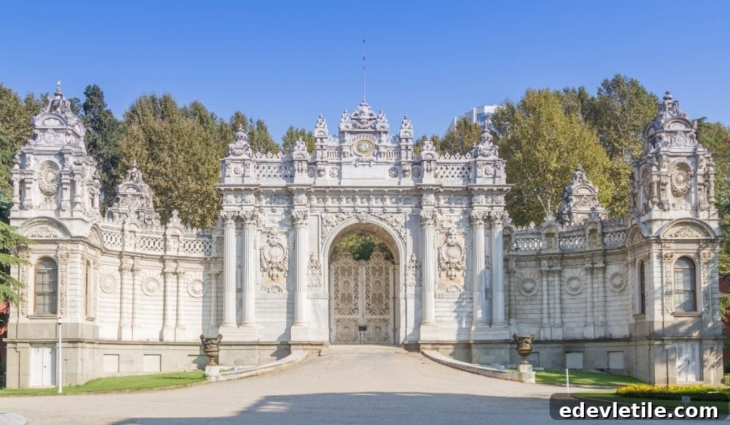 Ornate white marble gate at the entrance of Dolmabahçe Palace, showcasing its grand European-inspired architecture and baroque details.