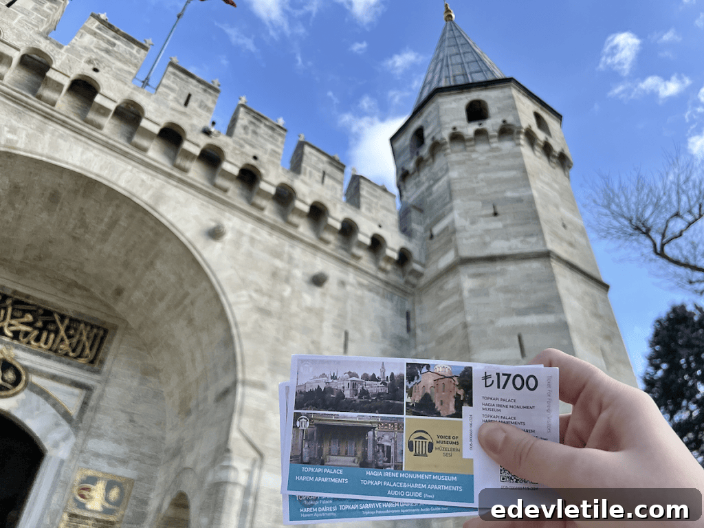 The author holding a Topkapi Palace ticket in front of the palace’s iconic entrance gate with pointed towers.