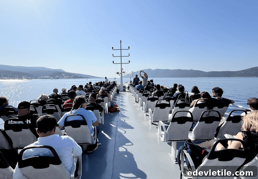 Passengers sitting on the upper deck of a ferry cruising through the Aegean Sea with scenic coastal views in the distance.