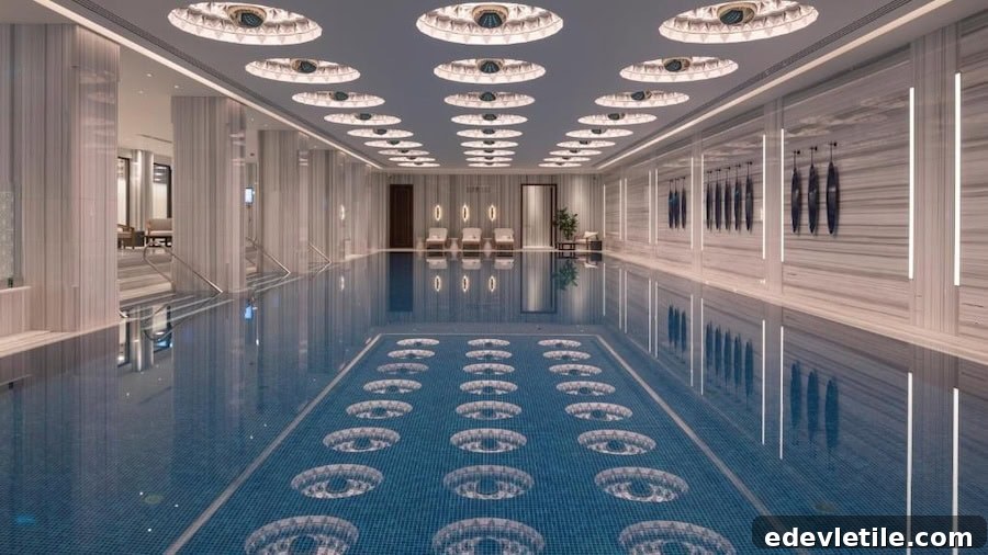 Elegant indoor pool at The Peninsula Istanbul, featuring intricate mosaic tiles and a row of lounge chairs under artful circular ceiling lights.