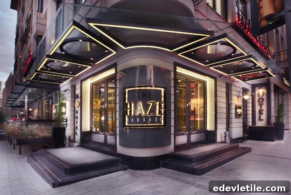 Stylish entrance of The Haze Karaköy Hotel near Galataport at twilight, with glowing signage and sleek Art Deco-inspired design.