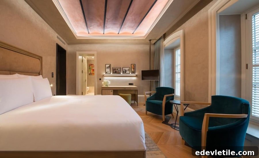 Chic guest room at 10 Karaköy Hotel with a high ceiling, minimalist decor, velvet chairs, and warm ambient lighting.