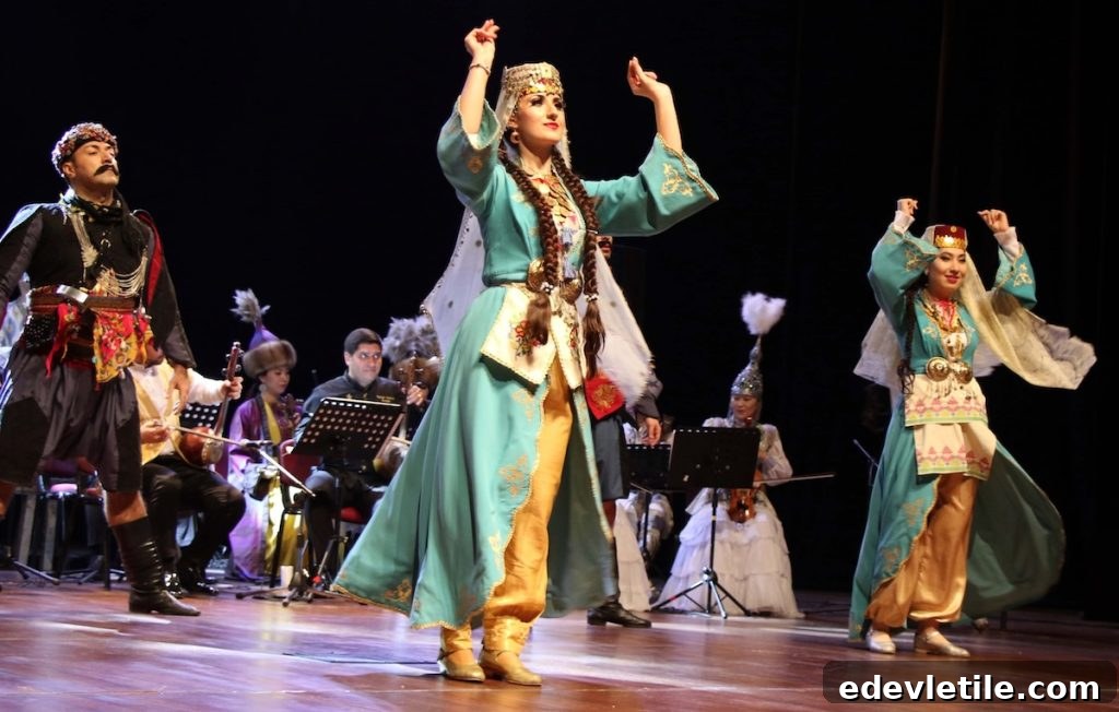 Men and women performing a traditional Turkish folk dance for Nowruz on stage, dressed in ornate regional costumes with musicians in the background.