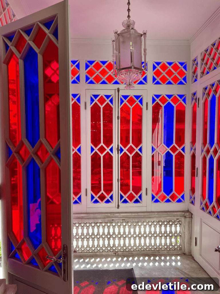 Interior view of Yildiz Palace’s glass veranda featuring red and blue diamond-patterned stained glass windows and a central hanging lantern.