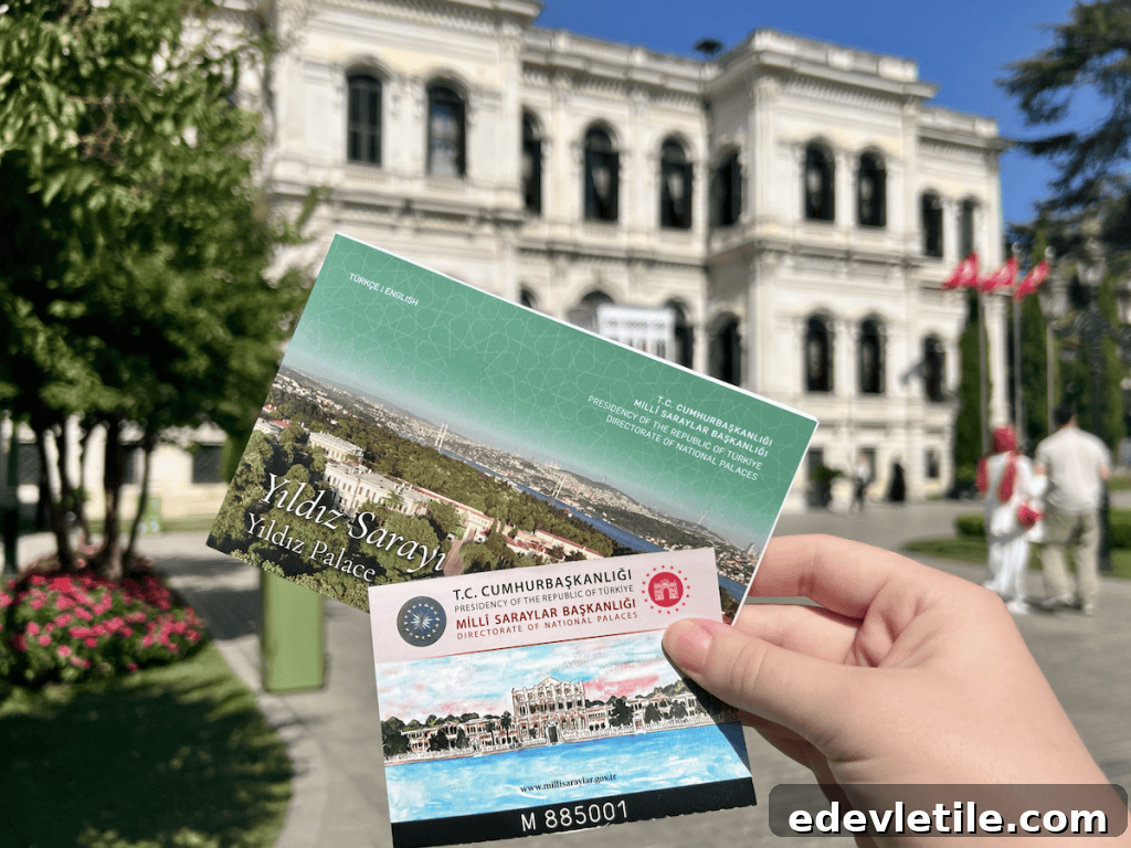 The author holding entry tickets to Yıldız Palace, with the ornate white exterior and lush palace grounds visible in the background.