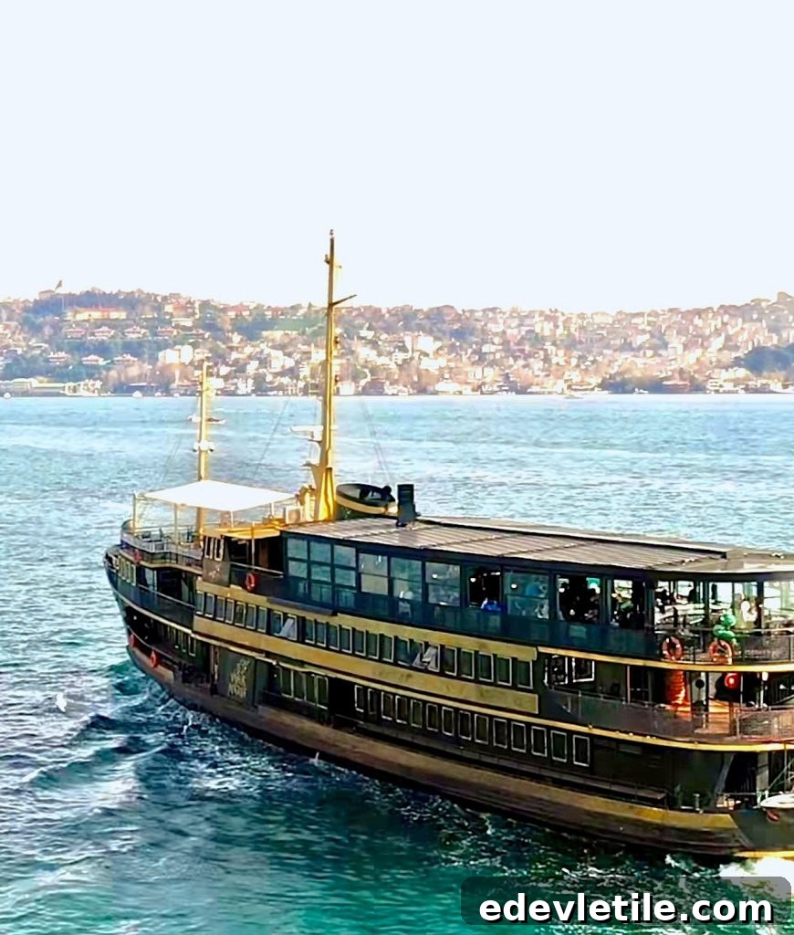 A large traditional-style ferryboat sails across the Bosphorus in Istanbul, with the city skyline visible in the background.