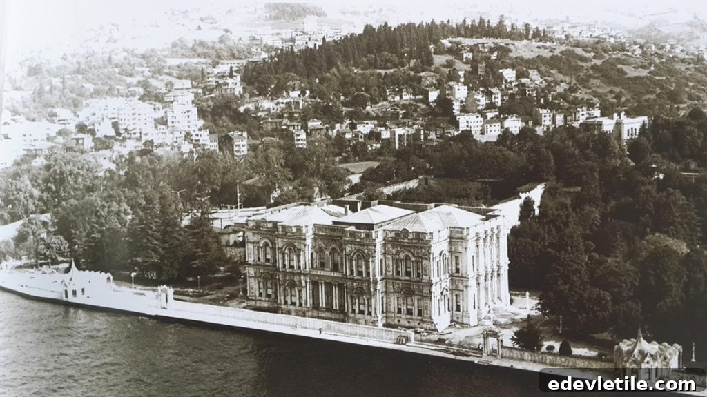 Vintage black-and-white aerial photo of Beylerbeyi Palace along the Bosphorus shoreline, surrounded by dense trees and hillside buildings in Istanbul.