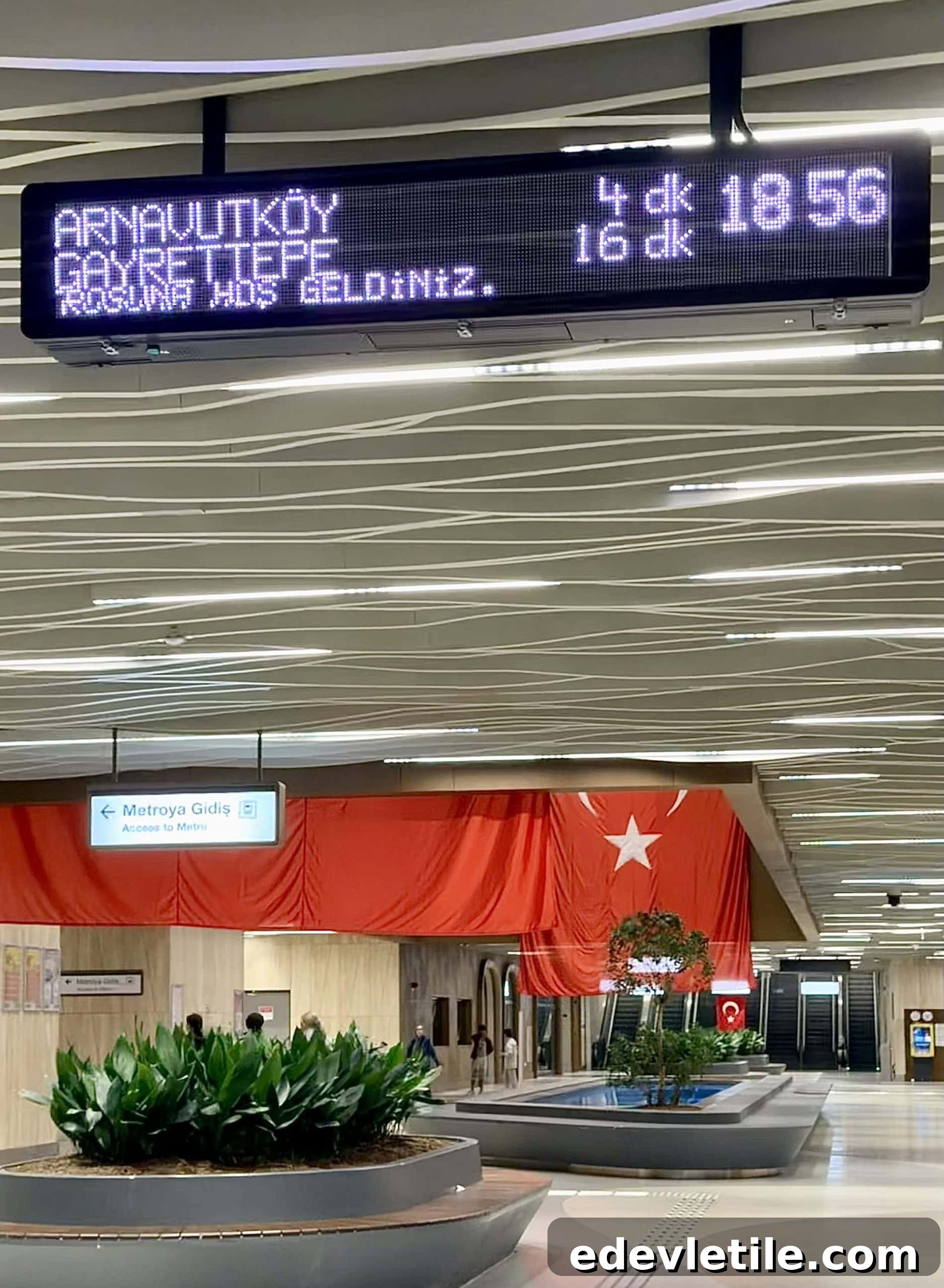 Digital metro departure board at Istanbul Airport showing Arnavutkoy and Gayrettepe with countdown times in minutes, guiding passengers taking the M11 line from IST Airport.