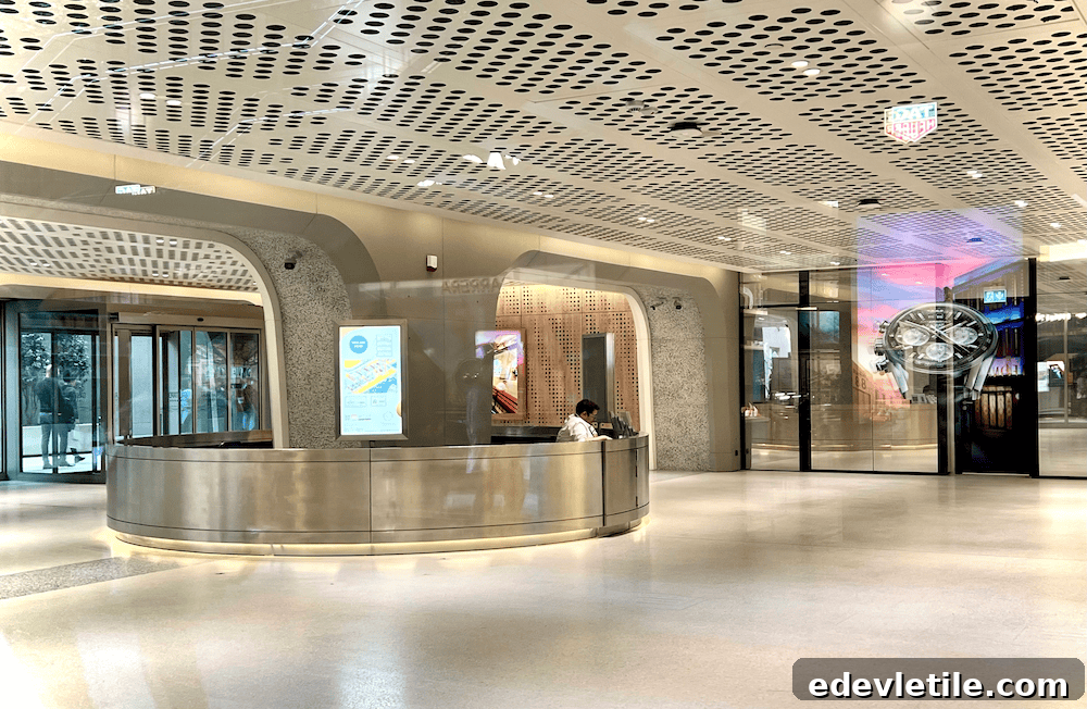 The information desk at Galataport cruise port in Istanbul. There is a man sitting behind a sleek desk and the exit behind him