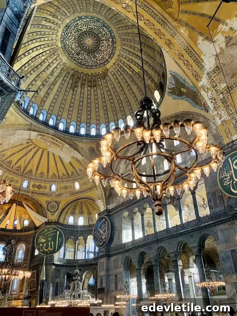 Interior of Hagia Sophia in Istanbul with a massive golden dome ornate chandeliers and circular Arabic calligraphy medallions