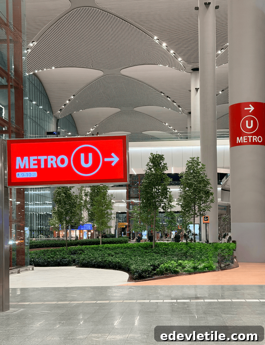 Red airport sign reading "METRO U" with an arrow pointing toward the metro station inside Istanbul Airport showing a public transport option 