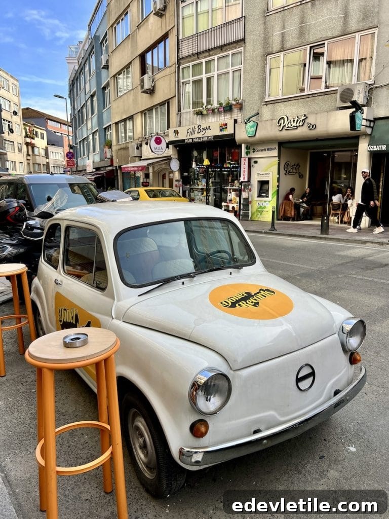 Vintage white car parked beside street tables on a lively side street in Besiktas, one of the coolest non touristy neighborhoods in Istanbul.